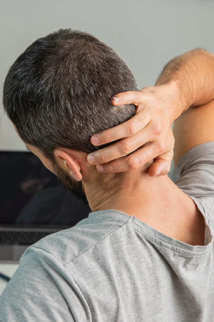Back View Man Holding His Neck While Working From Home