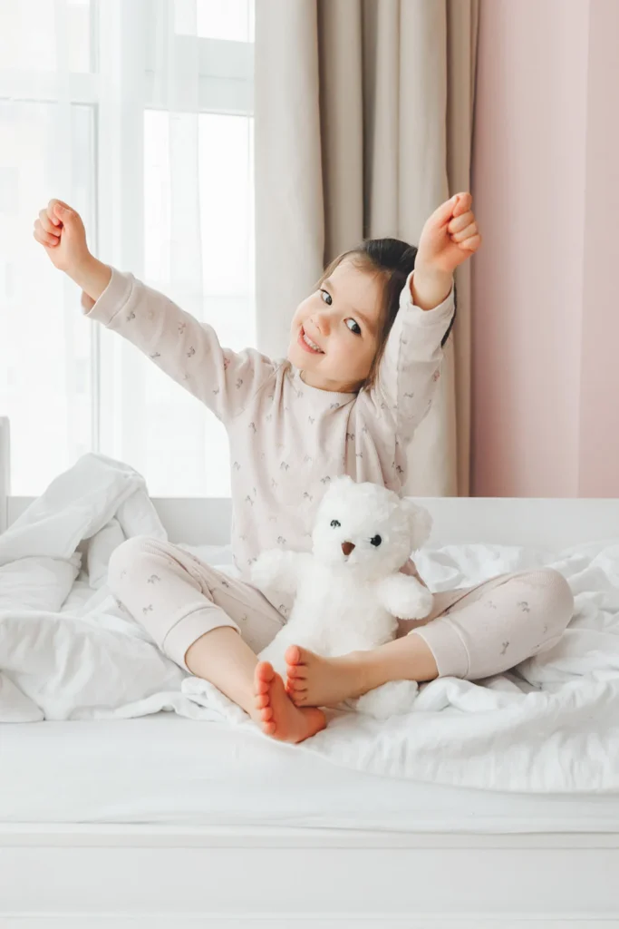 Girl Sits In Bed Stretching Arms Out