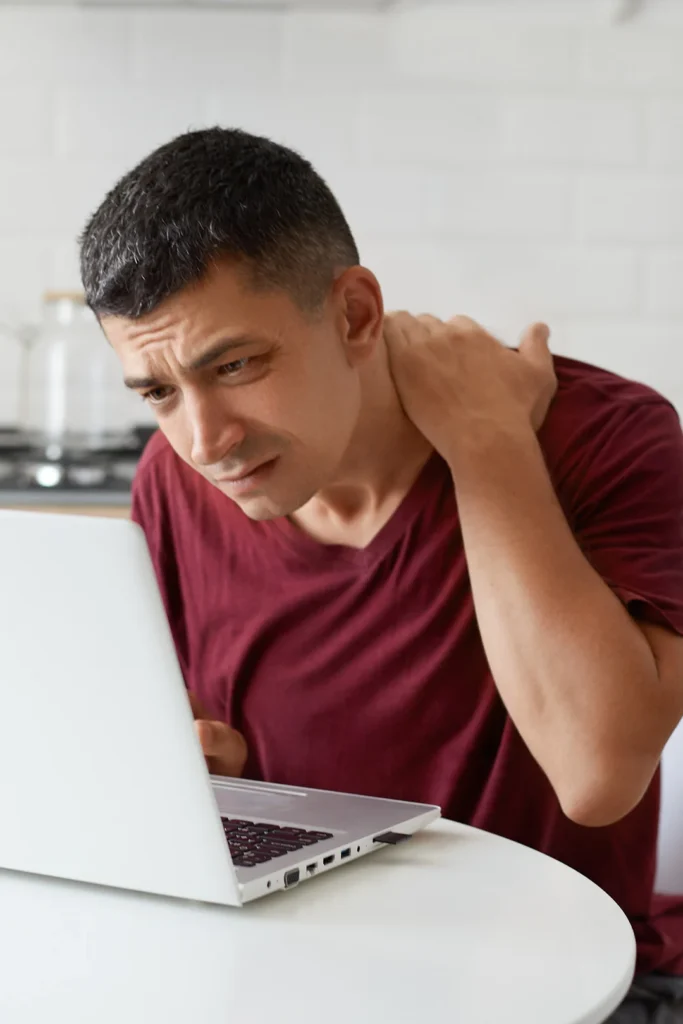 Man Holds Neck Staring At Computer