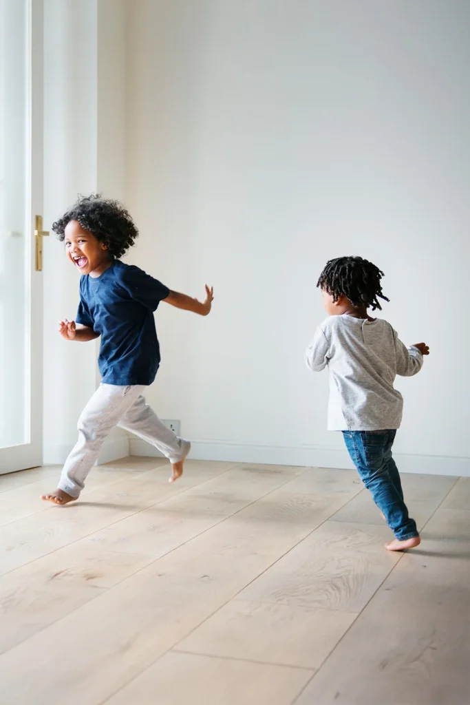 Two Boys Running Around The House